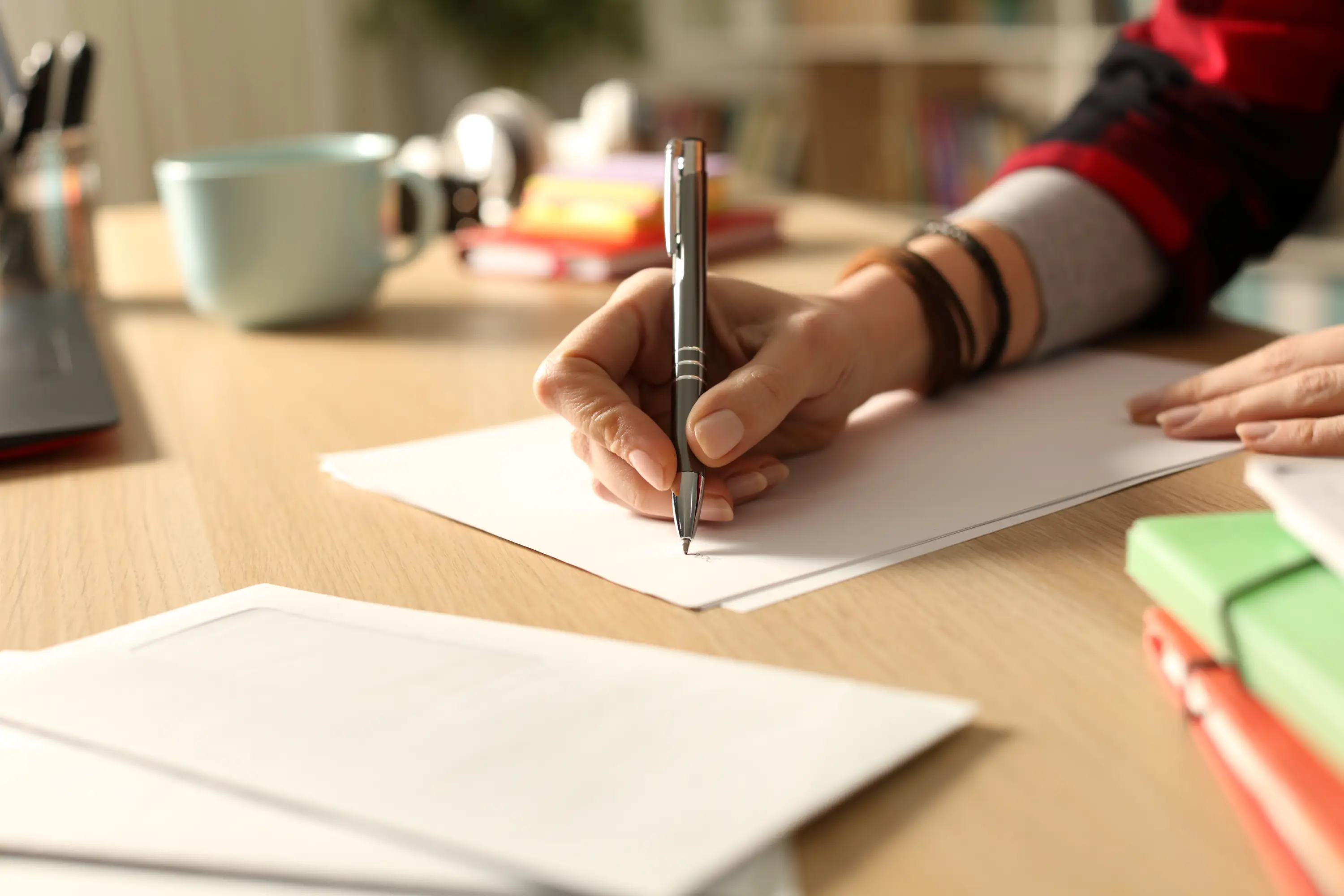 Hand writing on paper at a desk.