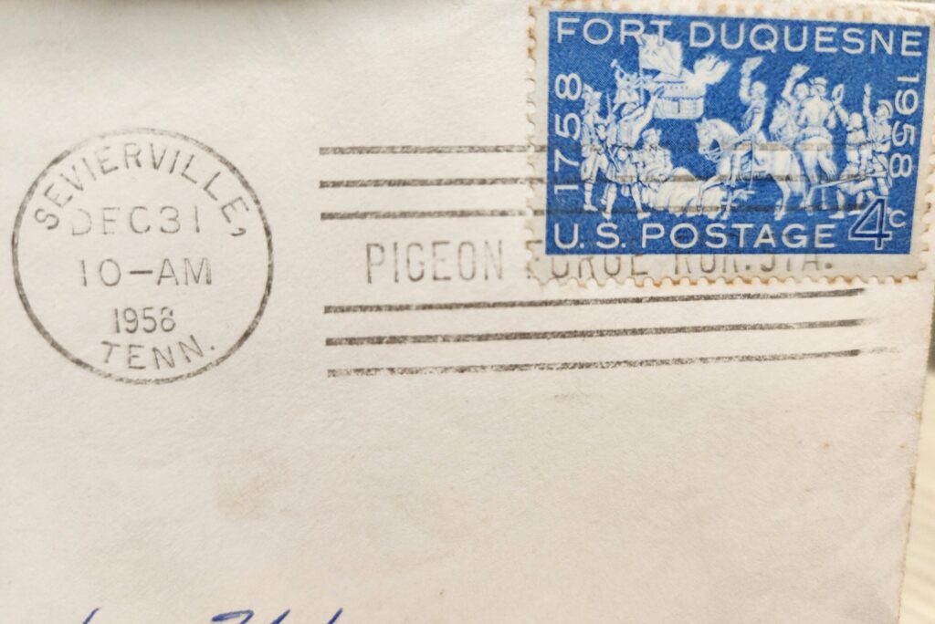 Close-up of an envelope corner with a blue postage stamp and postal markings.