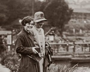 Two women smiling by a serene waterway.