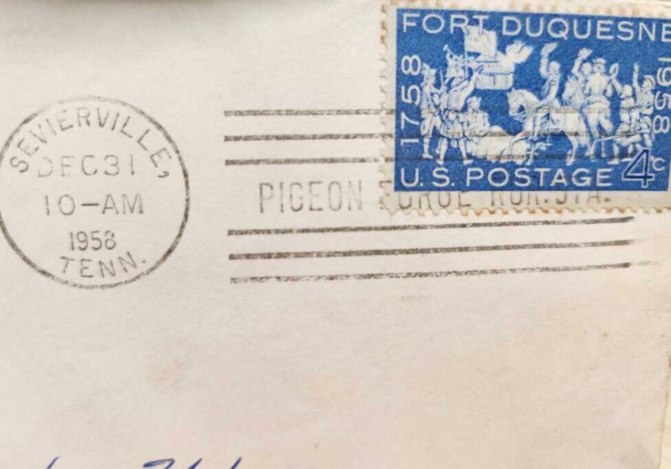 Close-up of an envelope corner with a blue postage stamp and postal markings.